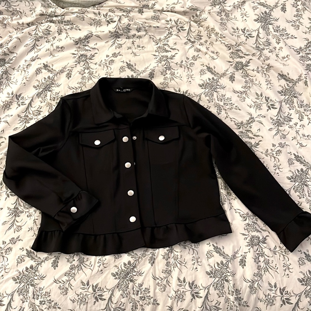 Black snap button with ruffles on sleeve cuff and around the bottom. Like new